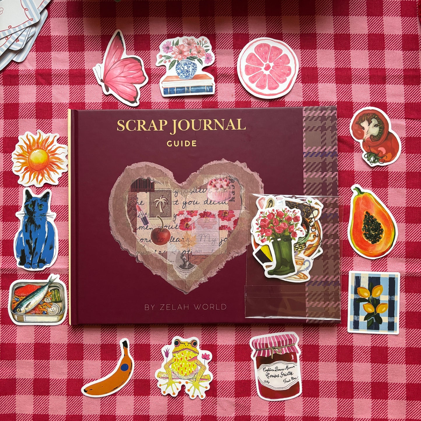 Scrap Journal Guide book by ZelahWorld surrounded by decorative stickers and ephemera on red gingham background